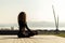 Woman meditating by peaceful sea