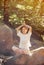 Woman meditating in pose of lotus in forest.