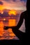 Woman meditating, relaxing in yoga pose at sunset, zen meditation