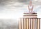 Woman meditating sitting on Books stacked by grey cloudy sky