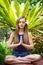 Woman meditating in the tropical garden