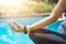 Woman meditating with wrist beads in a lotus yoga position at bl