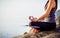 The woman meditating in a yoga pose on the tropical beach. Female meditating overlooking the beautiful sunrise. Healthy mind body