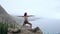 Woman meditating in yoga warrior pose at the ocean, beach and rock mountains. Motivation and inspirational fit and