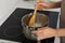 Woman melting wax on stove in kitchen, closeup. Making homemade candles