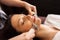 Woman with microcurrent face massager in spa