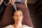 Woman with microcurrent face massager in spa