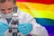 Woman with a microscope against LGBT flag background