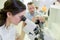 Woman with microscope in microelectronics laboratory