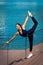 woman middle-aged fitness instructor doing training outdoor summer day city promenade by river