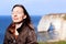 Woman mindfulness smiling doing breath exercises on top of normandy cliffs in the spring