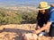 Woman with miner\'s pick hammer works as a geologist, studies the structure of the mineral soil of the mountain