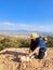 Woman with miner\\\'s pick hammer works as a geologist, studies the structure of the mineral soil of the mountain