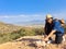 Woman with miner\'s pick hammer works as a geologist, studies the structure of the mineral soil of the mountain