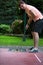 Woman at a minigolf court hits a black ball with an iron racket