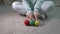 Woman in mint pyjamas play with balls of yarn of different colours.