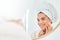 Woman, mirror and hands on face for skincare, smile and anti aging cosmetic results in bathroom. Facial, beauty and