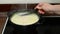 Woman mixes cheese soup in a saucepan on stove