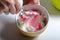 A woman mixes a cream with food coloring. Cream for decorating the cake with layers of different colors