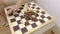 Woman mixes together chess pieces on chessboard