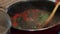 Woman mixing food on cooking pan, preparing tomato sauce with spinach and tuna fish for delicious pasta dish