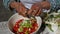 Woman mixing ingredients for homemade tabbouleh