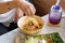 Woman mixing ingredients of Rice salad set on wood plate