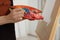 Woman mixing paints on palette near easel in studio, closeup