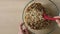 Woman mixing up walnuts, pumpkin seeds, oat and sweetened coconut flakes to make granola