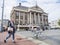 Woman with mobile phone passes city hall of groningen in the netherlands