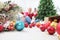 Woman with mobile phone prepare christmas tree with cardboard boxes full of christmas balls and decorations, preparation concept