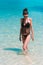 Woman model bathing in blue water on the beach of Phi Phi Island, Thailand.