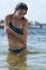 Woman model at the beach in bright sunlight.