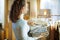 Woman in modern house in sunny winter day holding sweaters