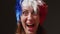 A woman with a mohawk on her head in the color of the French flag supports her sports team. Football fan at the stadium