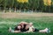 Woman mom sits on the grass in nature and does stretching warm-up, next to her baby crawls workout