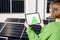 Woman monitors energy production from the solar power plant with a digital tablet