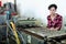 Woman monitors work of conveyor for planting seeds in trays