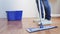 Woman with mop cleaning floor at home