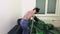 Woman with mop and green plastic bags in dirty room