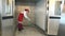 Woman mopping floor with brush for cleaning floor in industrial oven.