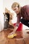 Woman mopping up water from a burst pipe with sponge, vertical