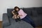 Woman, mother, hugged her son with her arms, kid sitting with her arms closed on the couch, concept of family education and