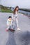 Woman mother parent, help support in learning, Little boy child 4-5 years old, learns ride skateboard, in summer on