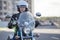 Woman a motorcycle driver sitting on bike, holding steering wheel, a classic chopper, open face helmet