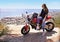 Woman, motorcycle and relax on cliff in city for ride, road trip or outdoor sightseeing in nature. Extreme female person