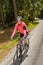 Woman mountain biking in sunny forest smiling