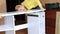 Woman mounting new white furniture, she putting a tabletop on a new half assembled dressing table