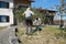 A woman with mower in front of the house