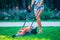 Woman mowing lawn in residential back garden